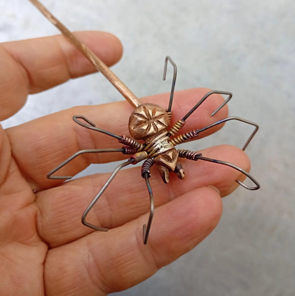 spider made of bronze and titanium attached to a hairstick. hårsticka dekorerad med en spindel gjord i brons och titan