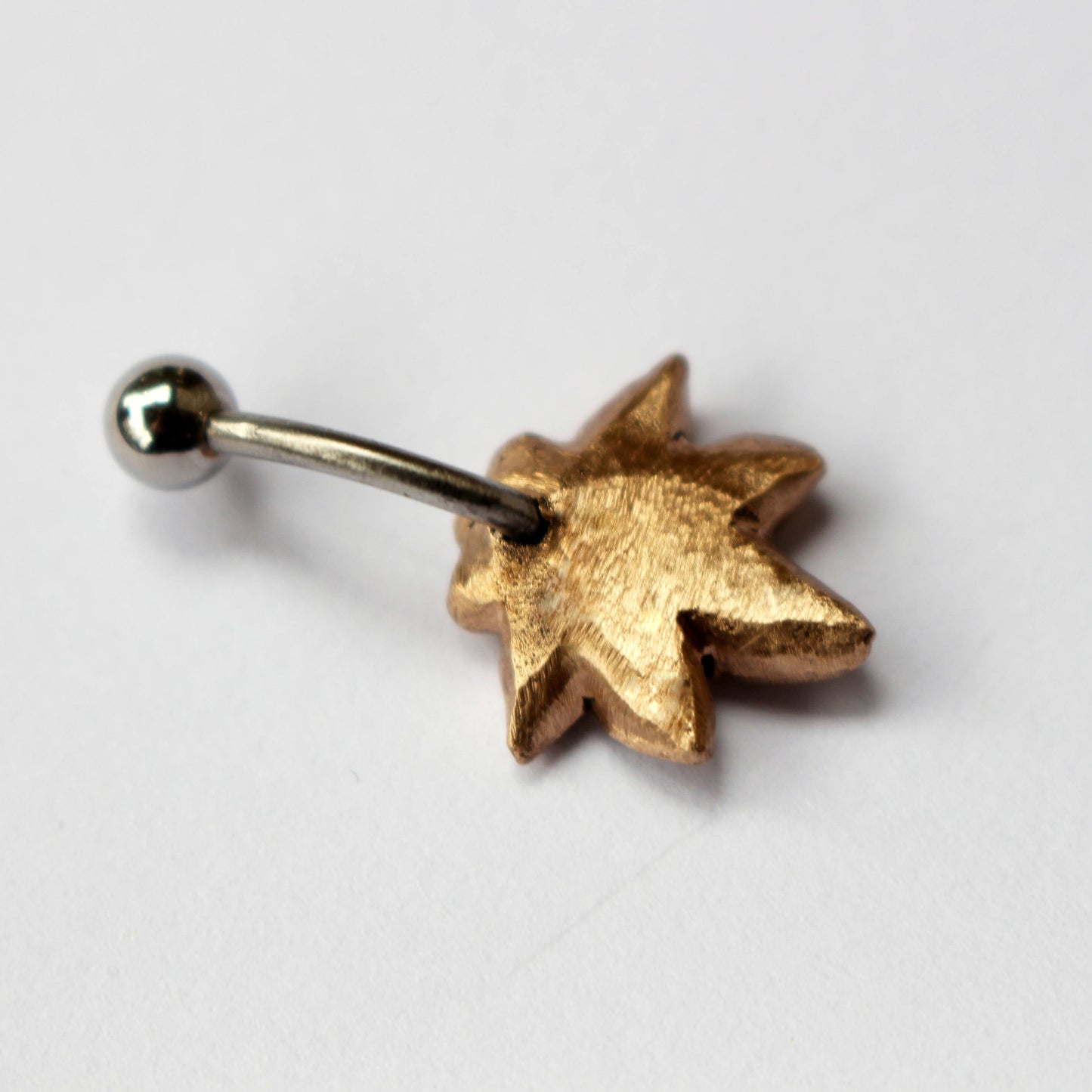 baksida, stjärnanis inspirerad navelring i brons och titan