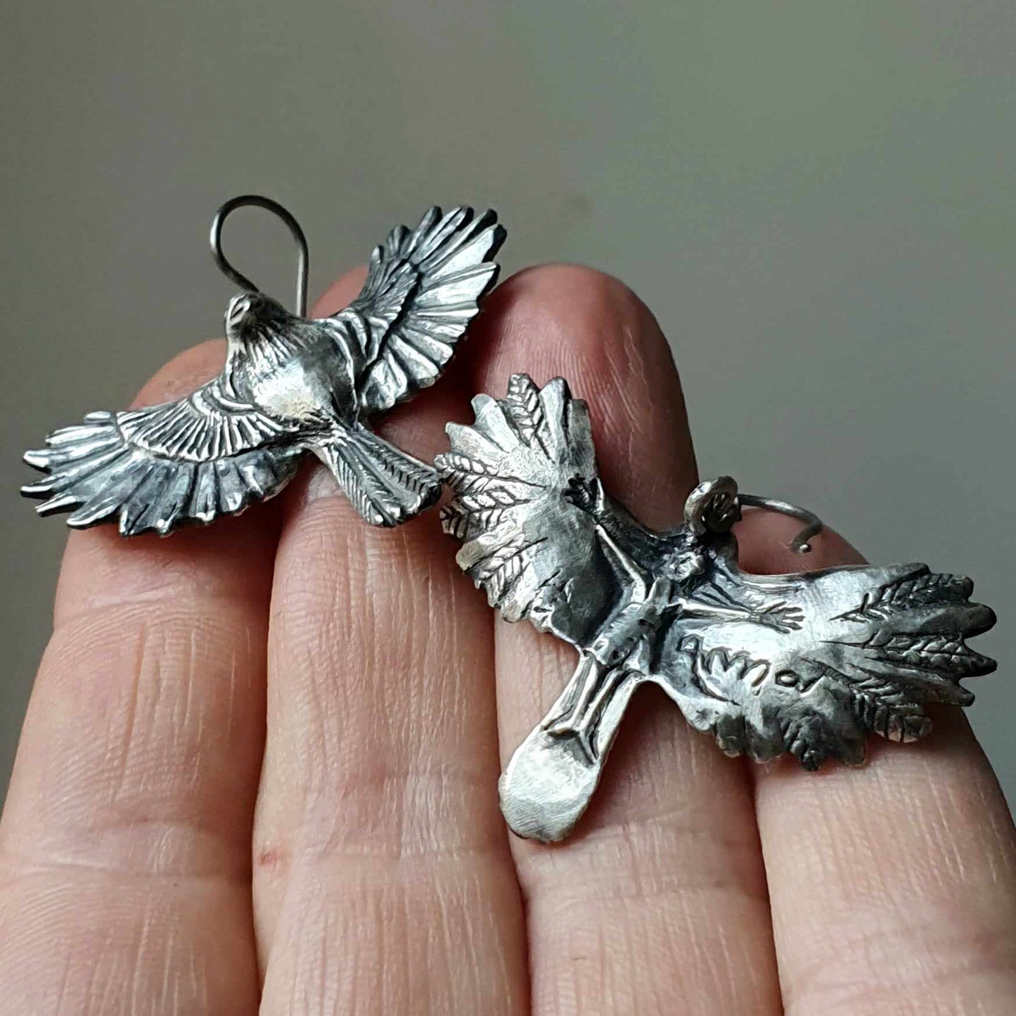bird earrings with sculpted flying bird on the backside
