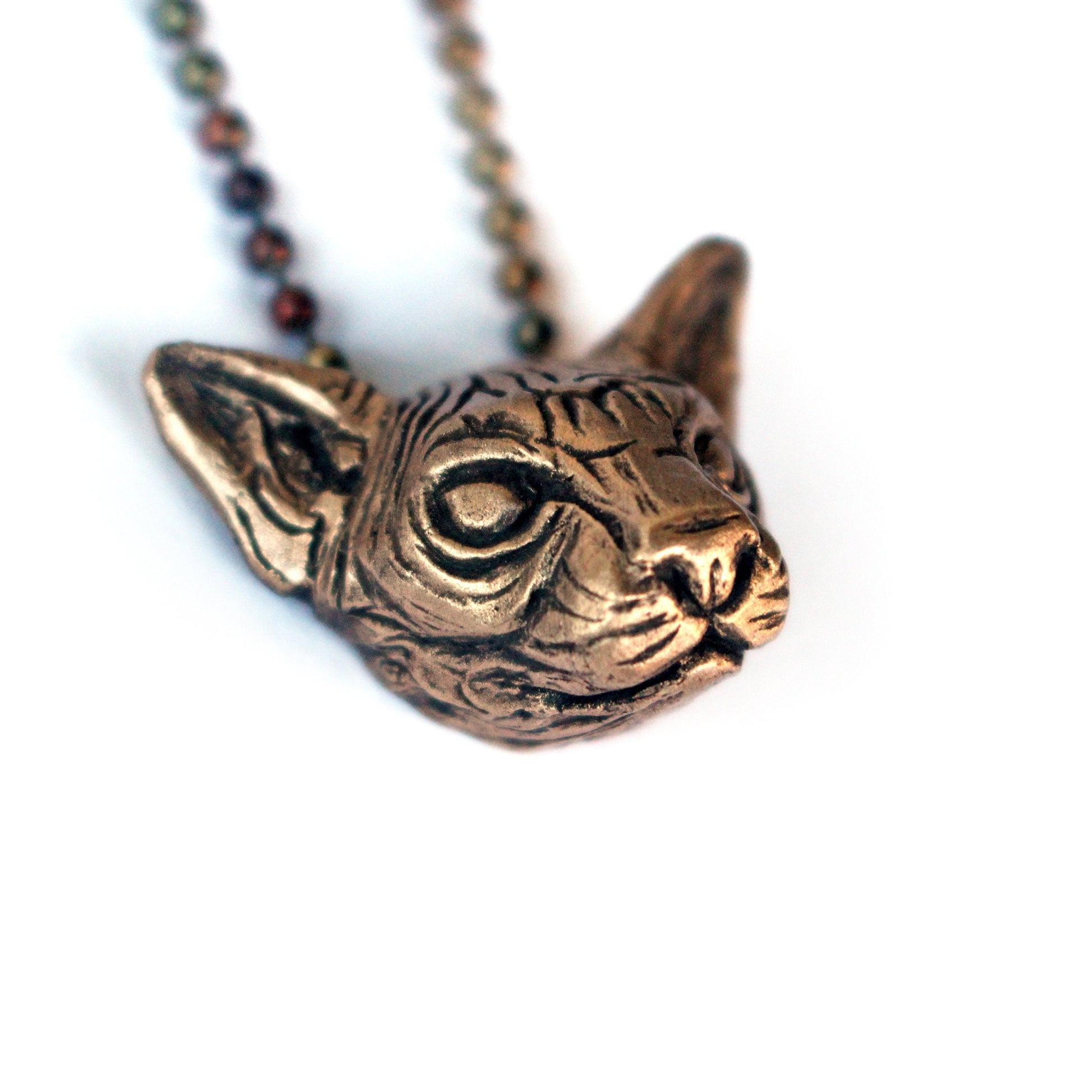 a sculpted bronze sphynx cat head necklace