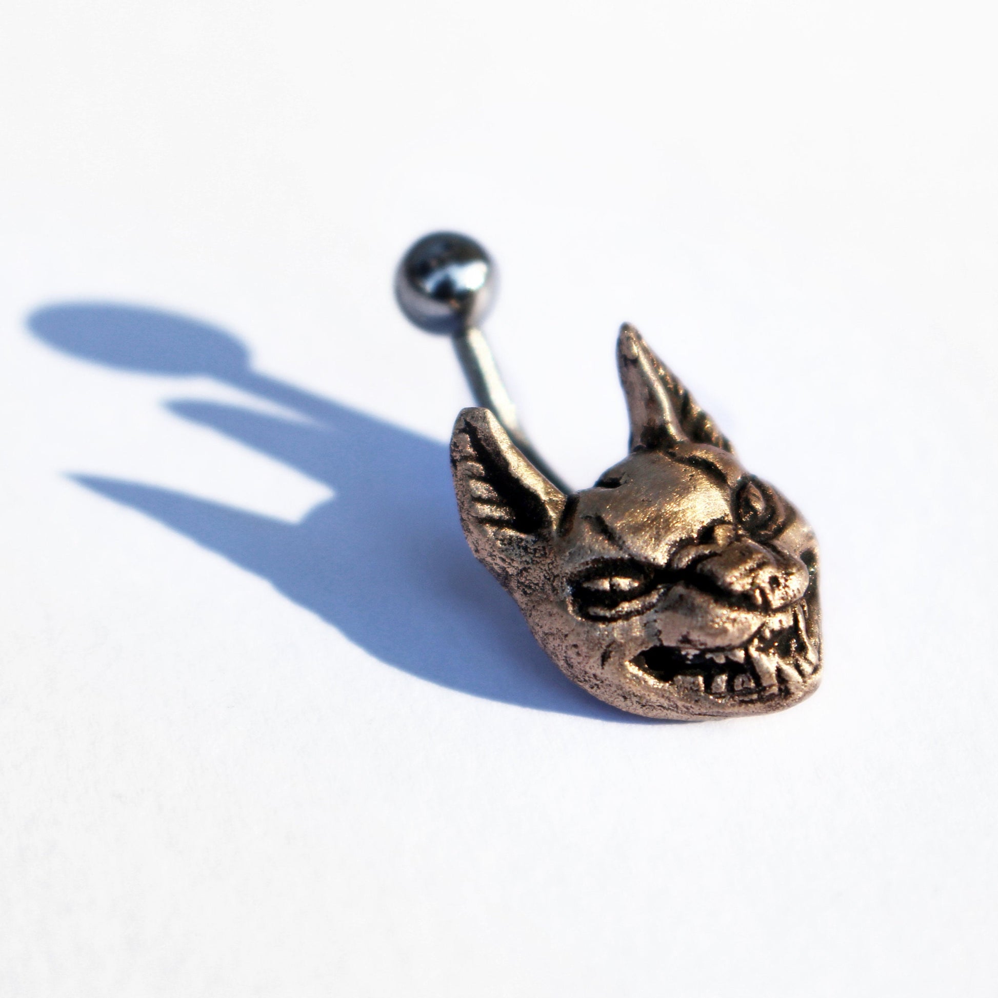belly button ring with a bronze-colored wild cat head and a curved barbell.