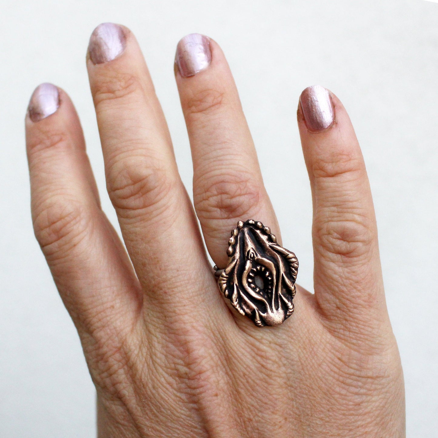 A bronze and steel ring featuring a sculpted Vagina Dentata design