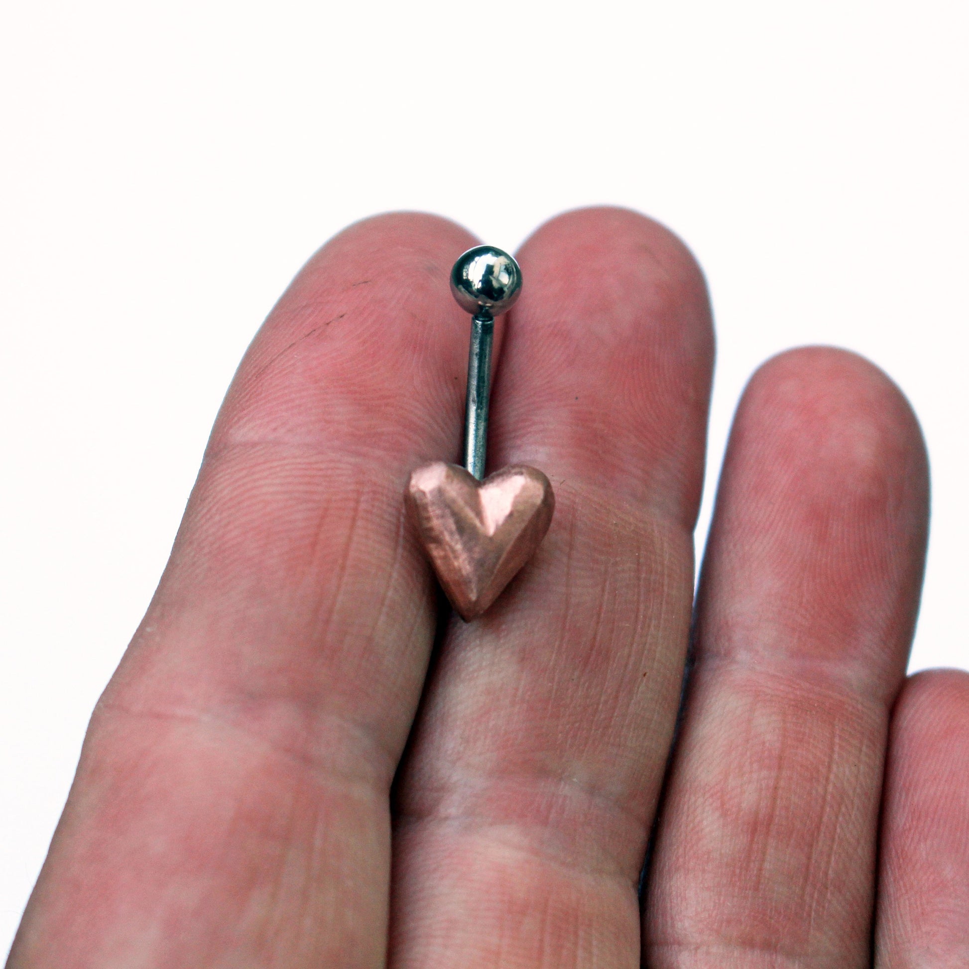belly button ring with pink puffy copper heart attached titanium barbell.