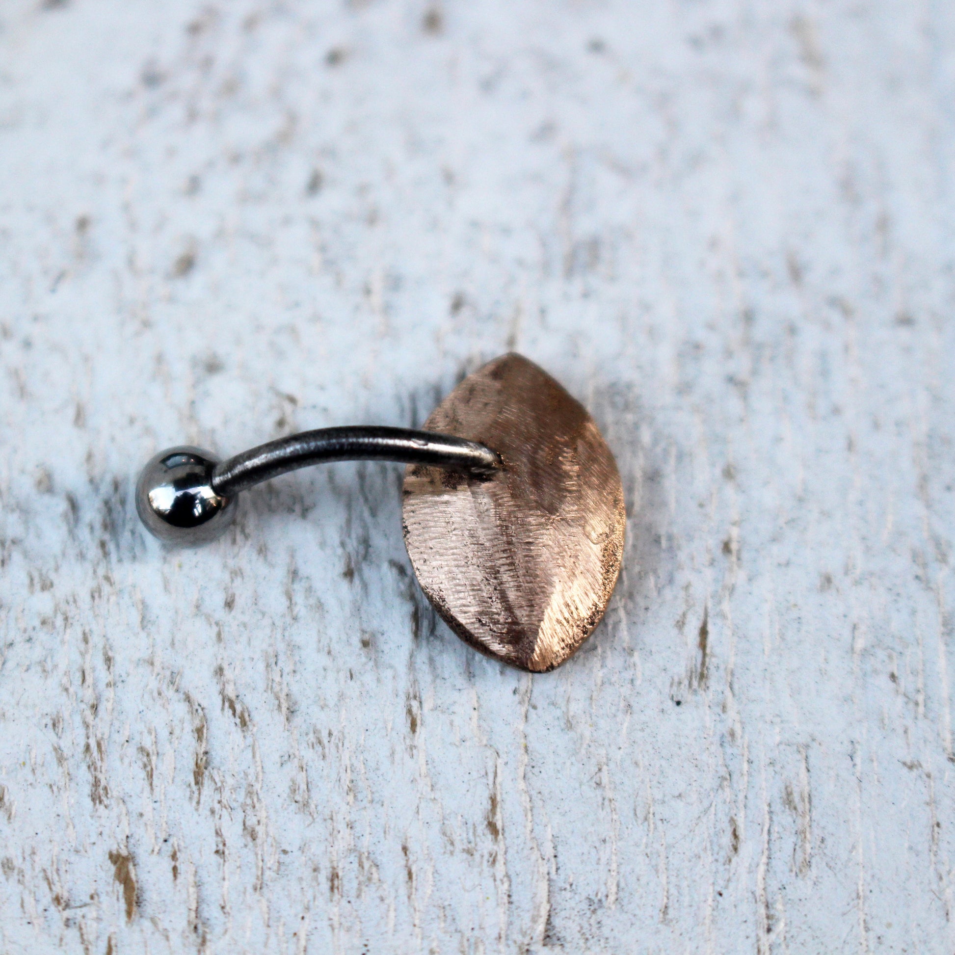 backside of abelly button ring with a bronze eye