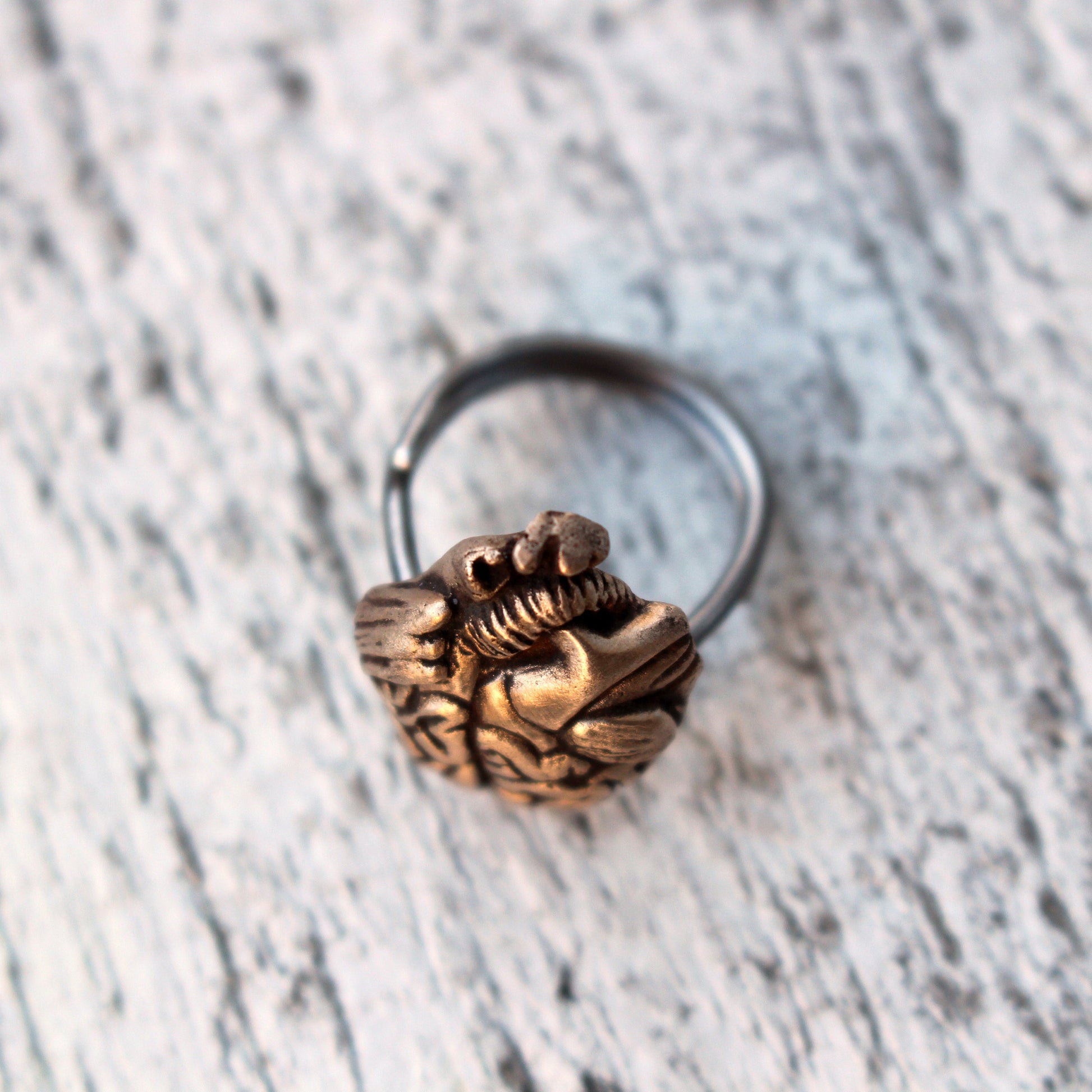 fingerring med symbol som ser ut som en blandning av ett hjärta o hjärna