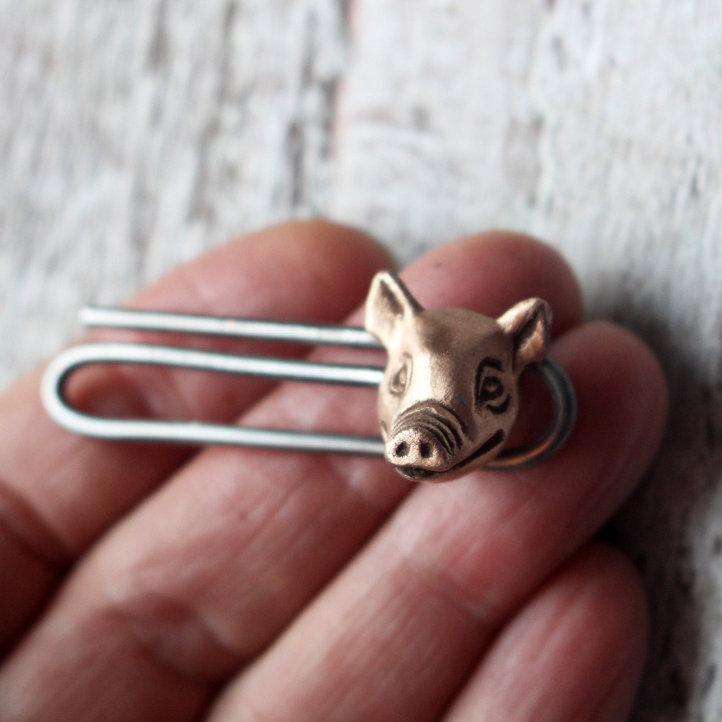 slipsnål  med ett grishuvud i koppar och klämma i stål