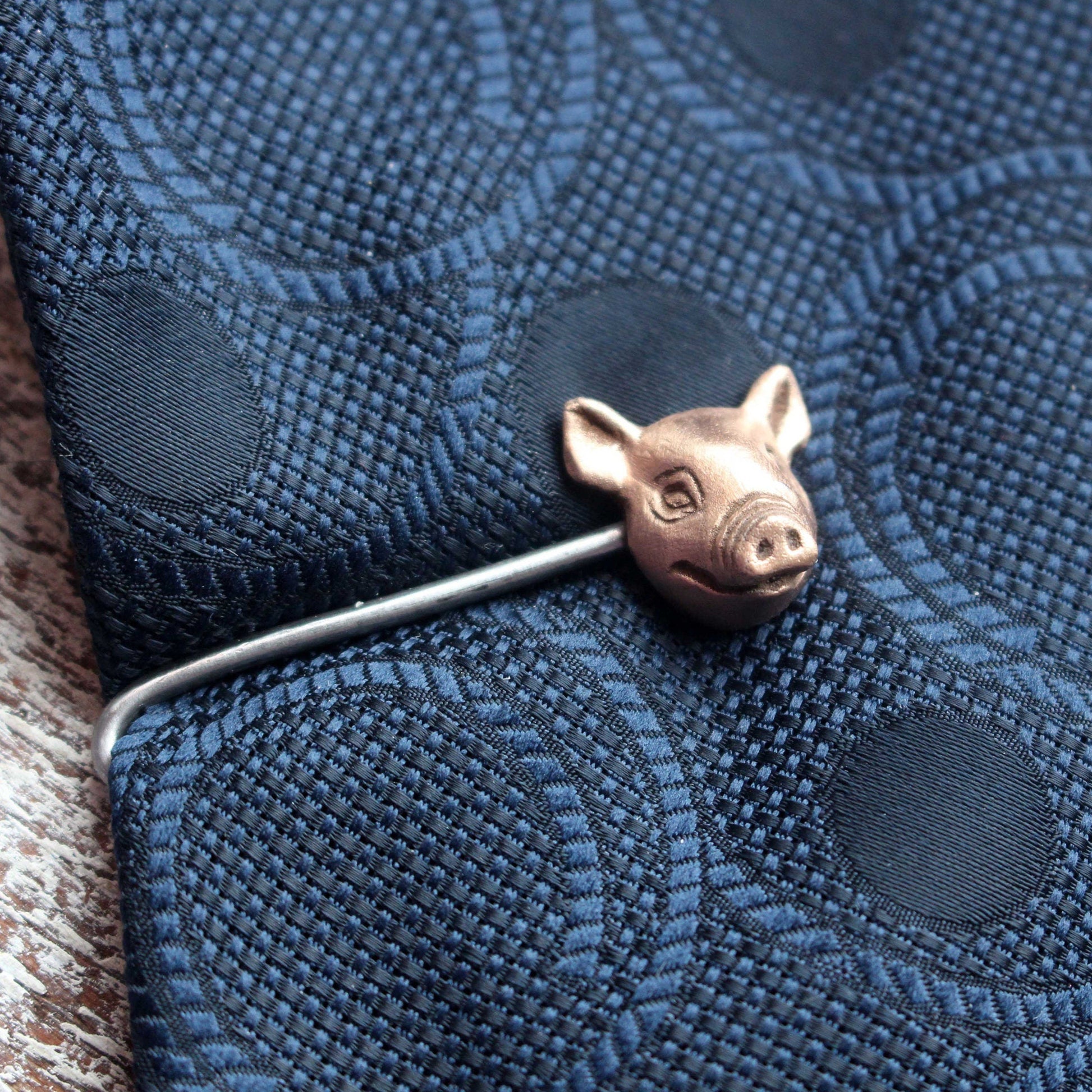 copper and steel tie pin/clip on a blue tie