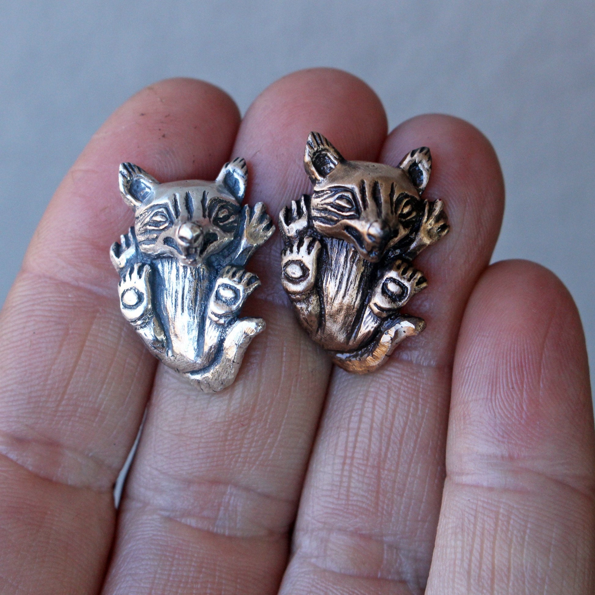Two wolf cub pendants, one in silver and one in bronze