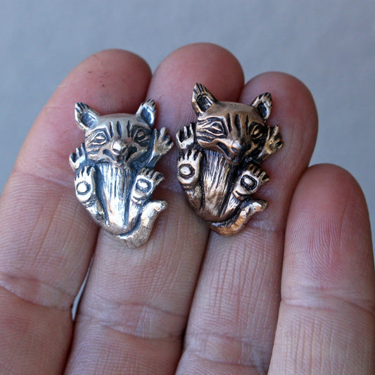 Two wolf cub pendants, one in silver and one in bronze
