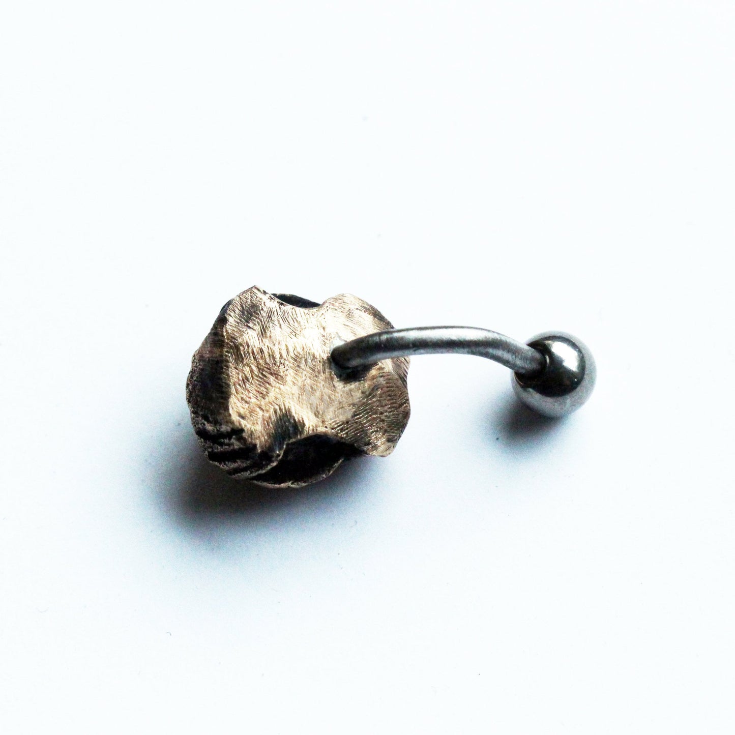 baksida, titan navelpiercingsmycke med skulpterade monstergaddar huggtänder i brons