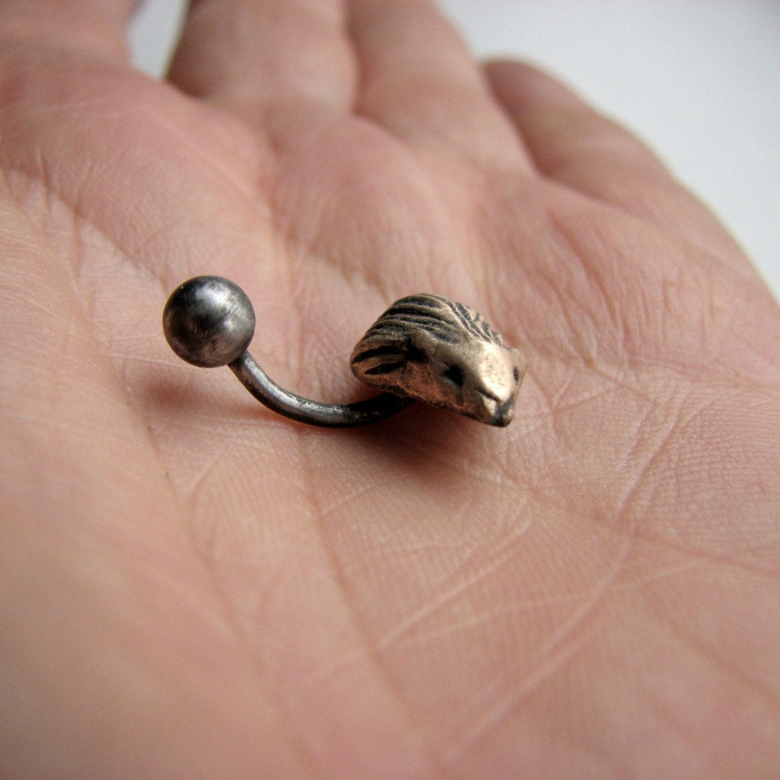 A belly button ring with a hedgehog- in bronze and titanium