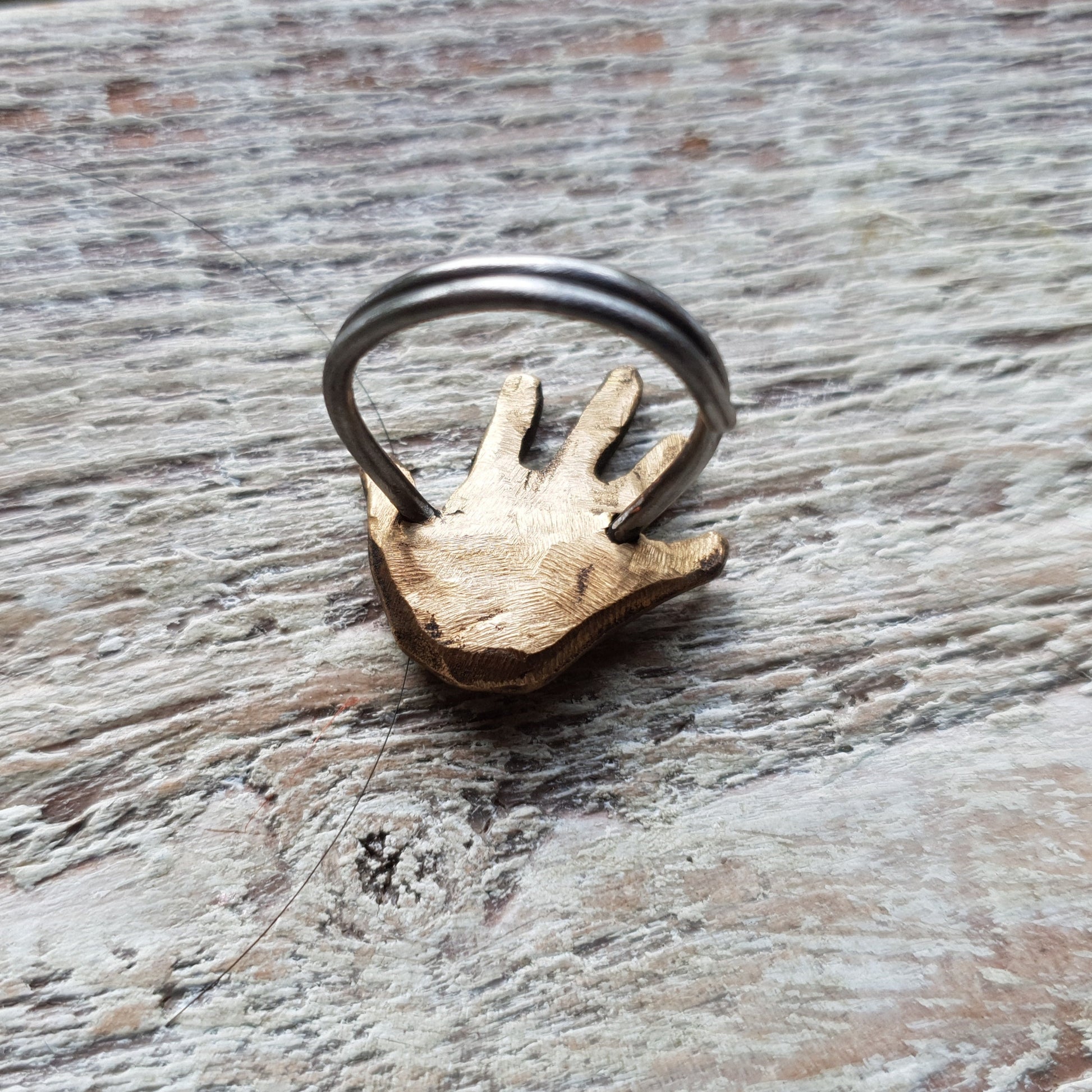 Bronze hand-shaped ring with a pink copper heart in the palm