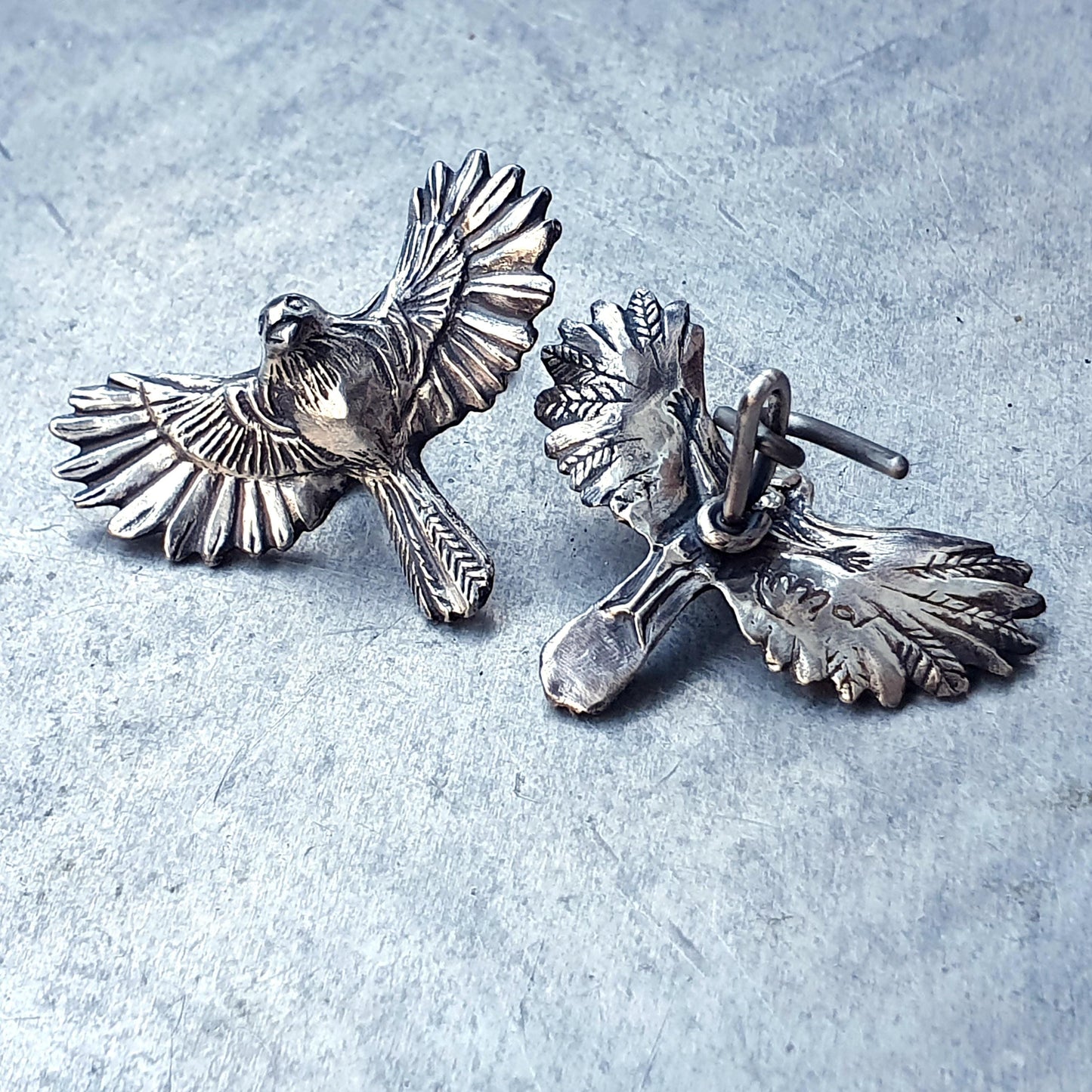 silver cufflinks with birds in mid-flight with wings spread