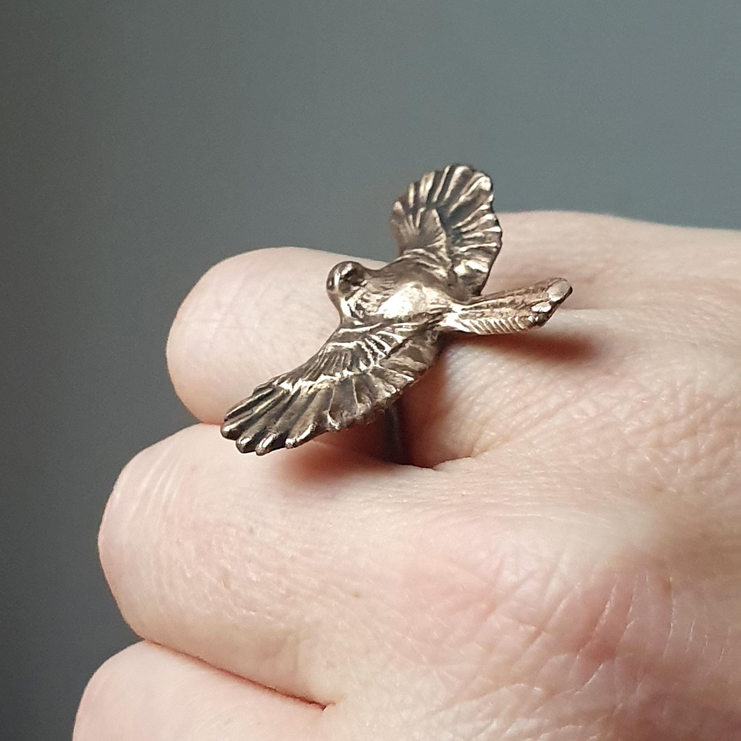 A bronze bird in flight statement ring