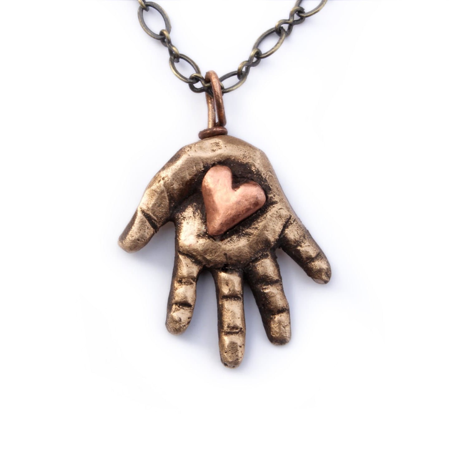 Bronze hand-shaped pendant with a heart in the palm on a white background