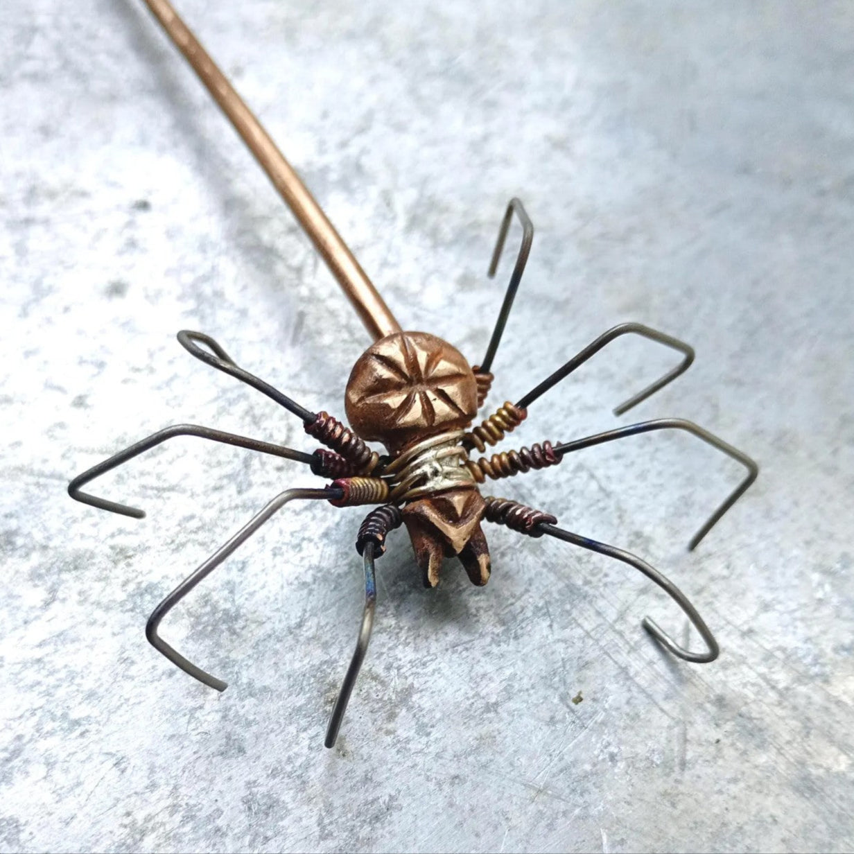 spider made of bronze and titanium attached to a hairstick