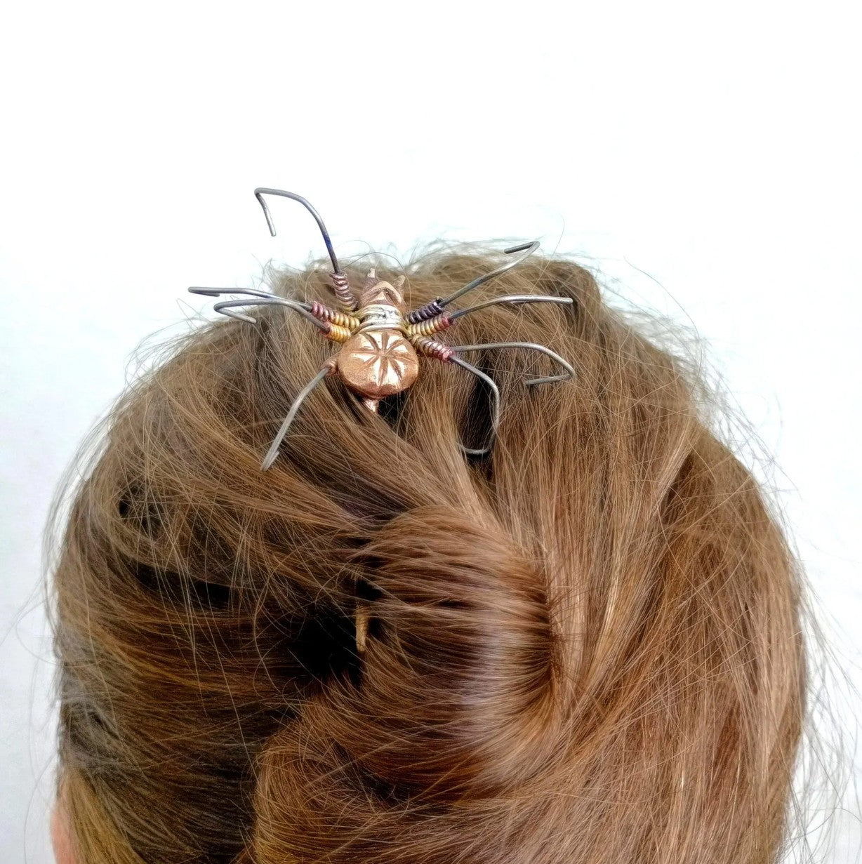 hårsticka dekorerad med en spindel gjord i brons och titan