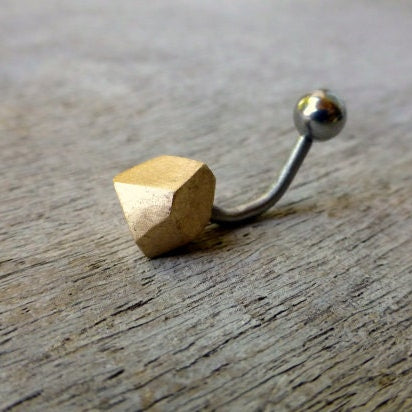A belly button ring with a bronze faceted cube end and surgical steel or titanium barbell