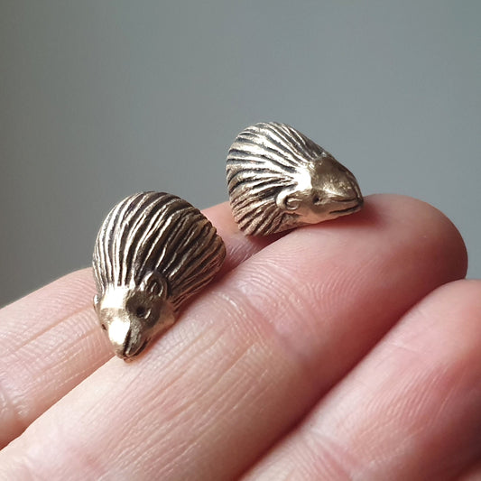 handgjorda manschettknappar med igelkottar skulpterade i brons