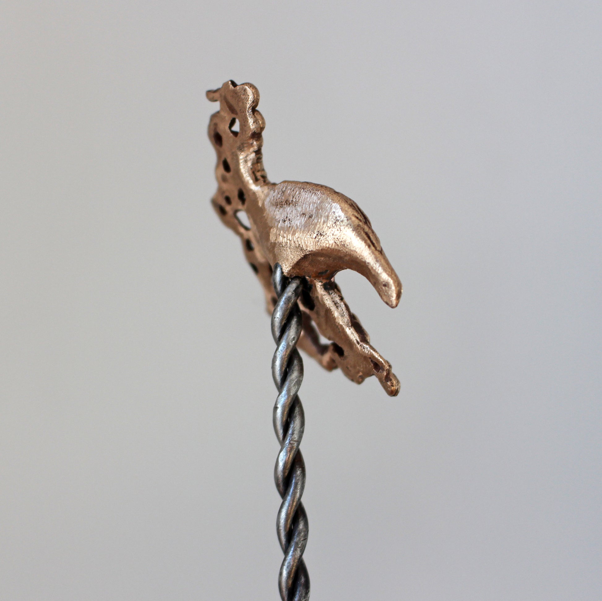 hårsticka med skulpterat korphuvud i brons och smidd pinne av stål, baksida