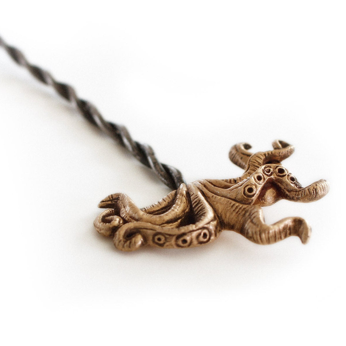 hårsticka med bläckfisk tentakler skulpterad i brons