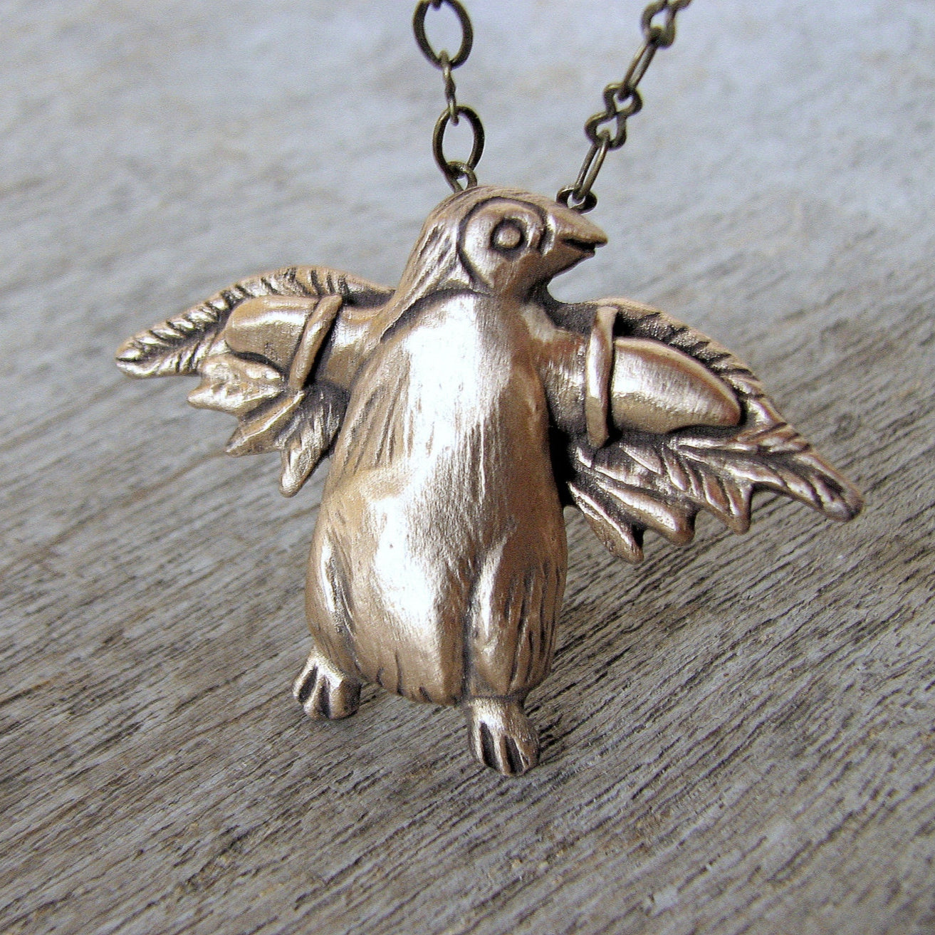 halsband med flygande pingvin i brons