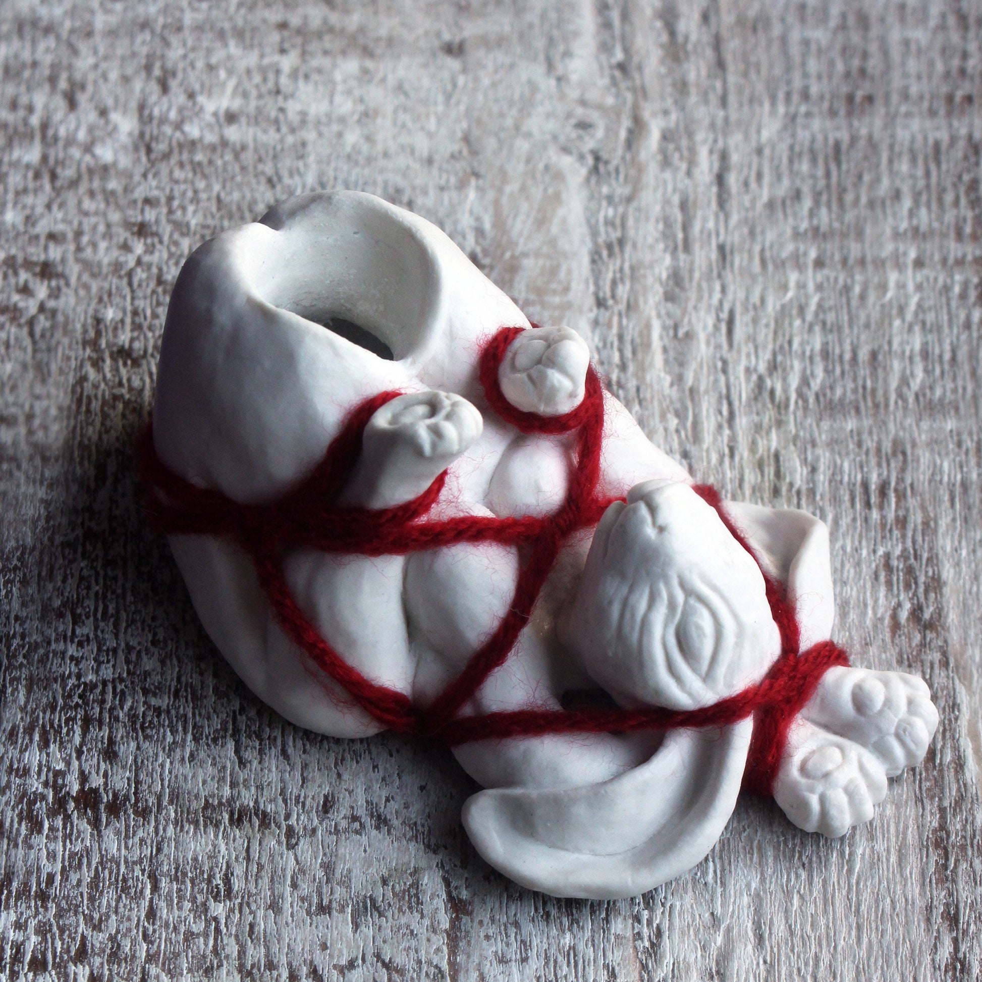 shibari bdsm skulptur ljusstake av en vit porslinskanin bunden med röda rep