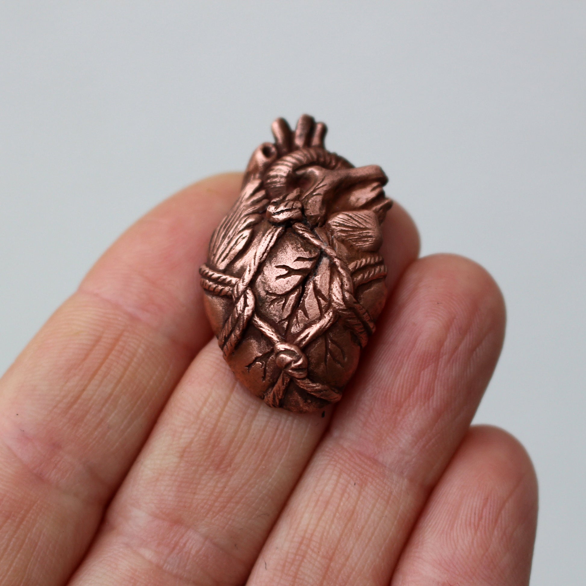 Brosh med ett skulptera anatomiskt hjärta bundet med rep, shibari smycke