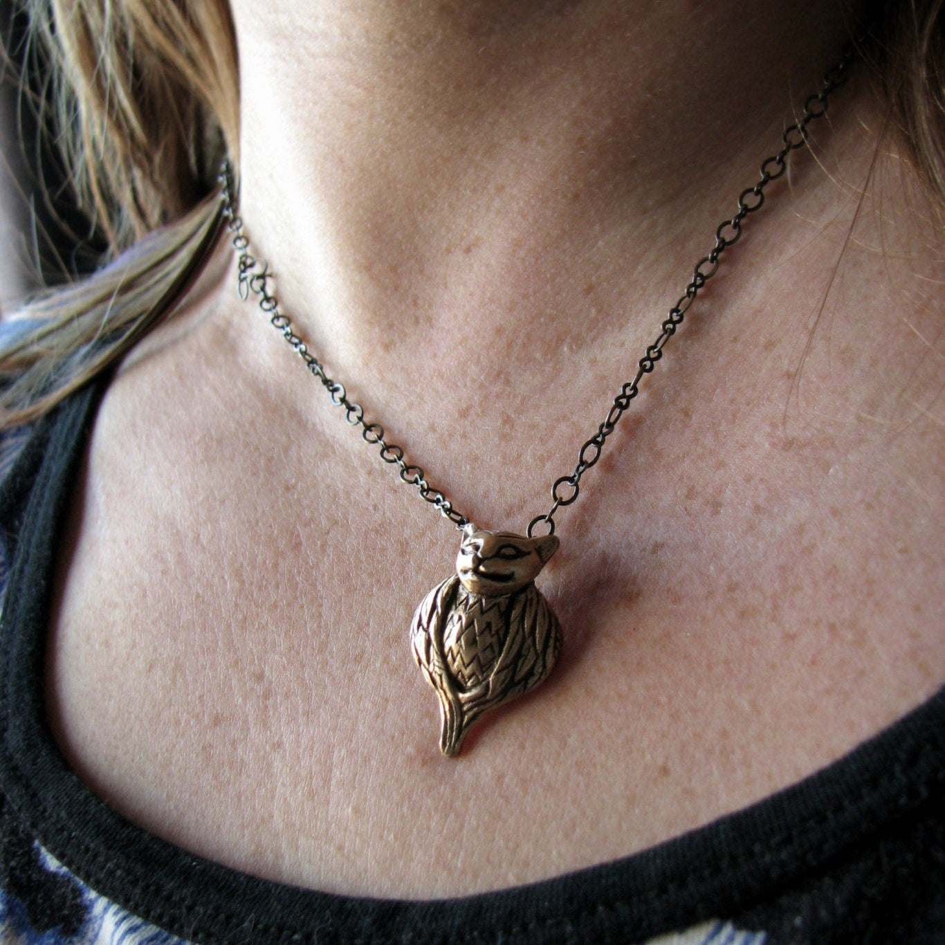 Necklace with a tawny owl pendant, a cat with a bird body worn by a person