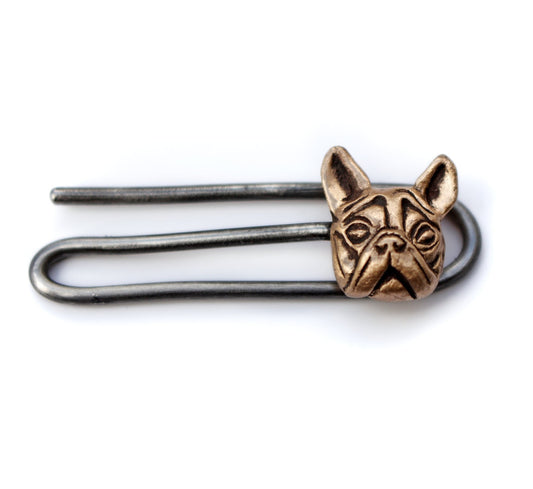 A handcrafted bronze tie clip with a detailed dog head sculpted on it, displayed on a white background.