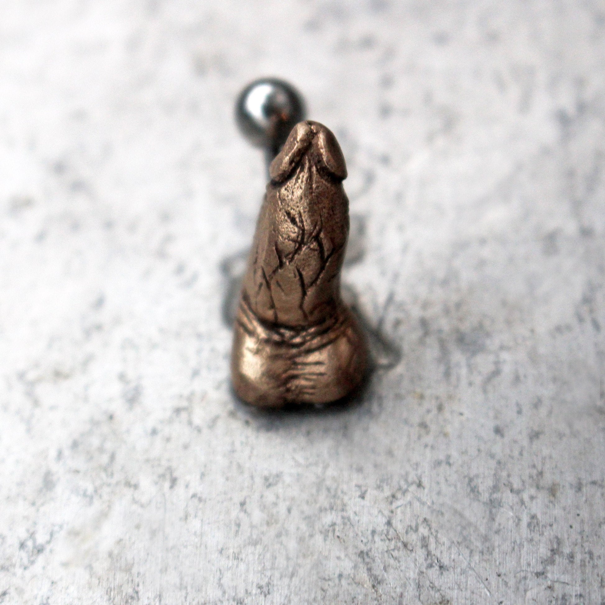 belly button piercing jewelry with a penis sculpted in bronze