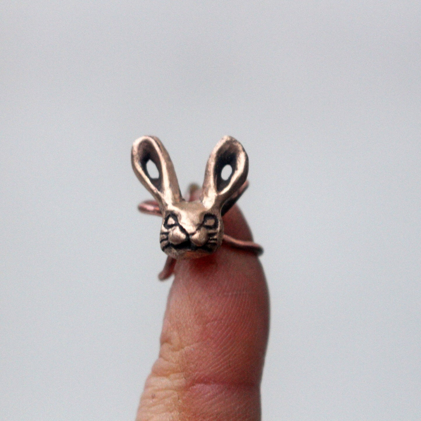 earcuff i brons med skulpterad kanin eller har huvud