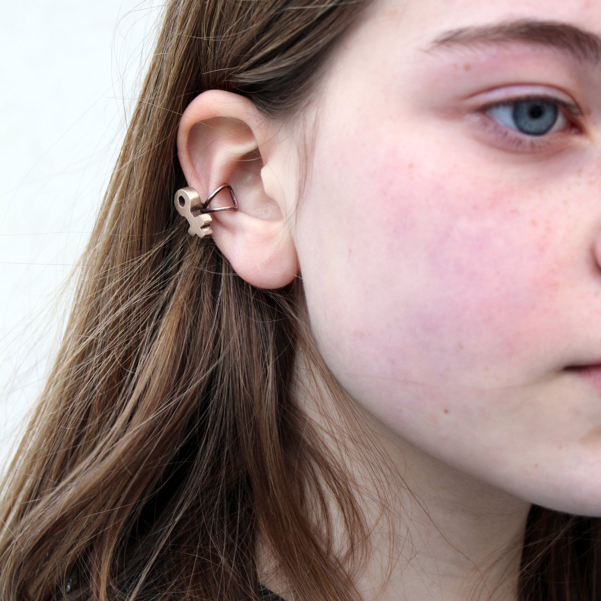 örhänge earcuff med feministsymbol skulpterad i brons på modell