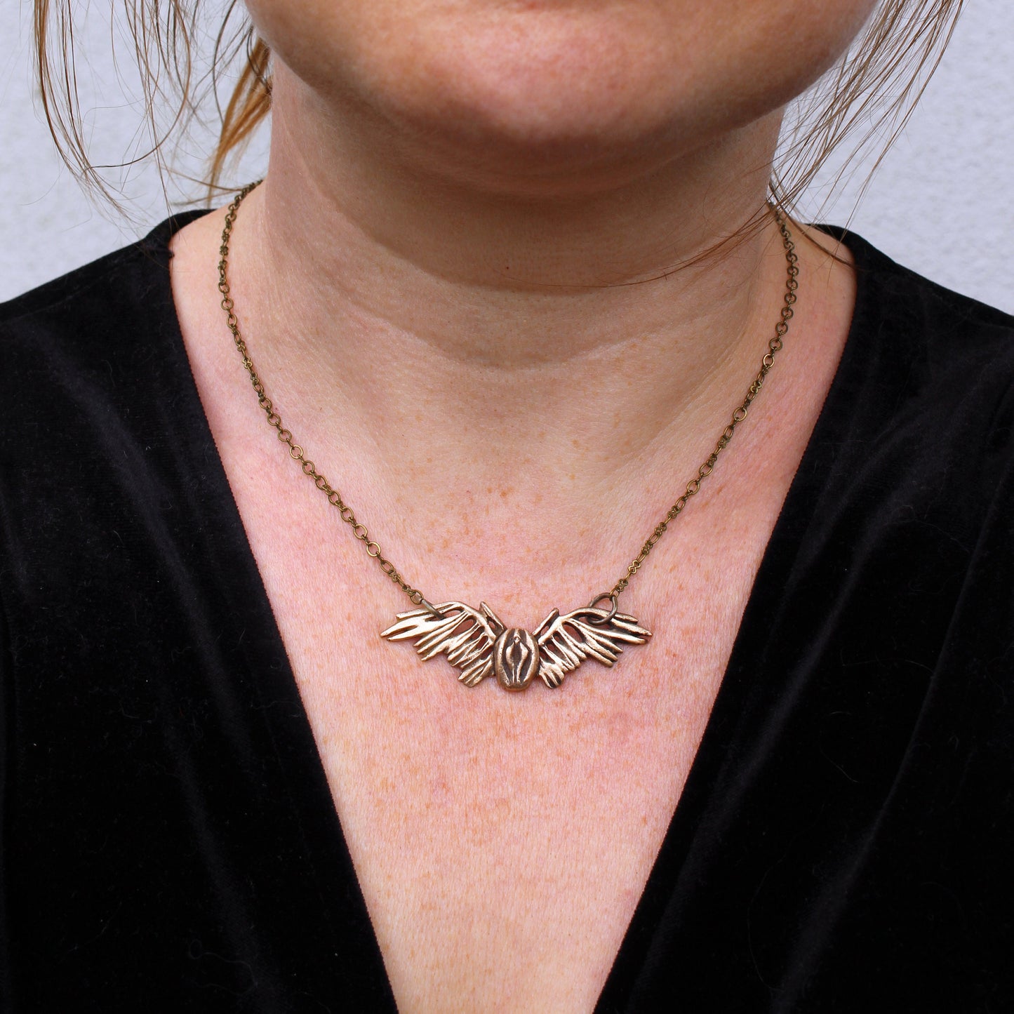 necklace with a vulva with wings