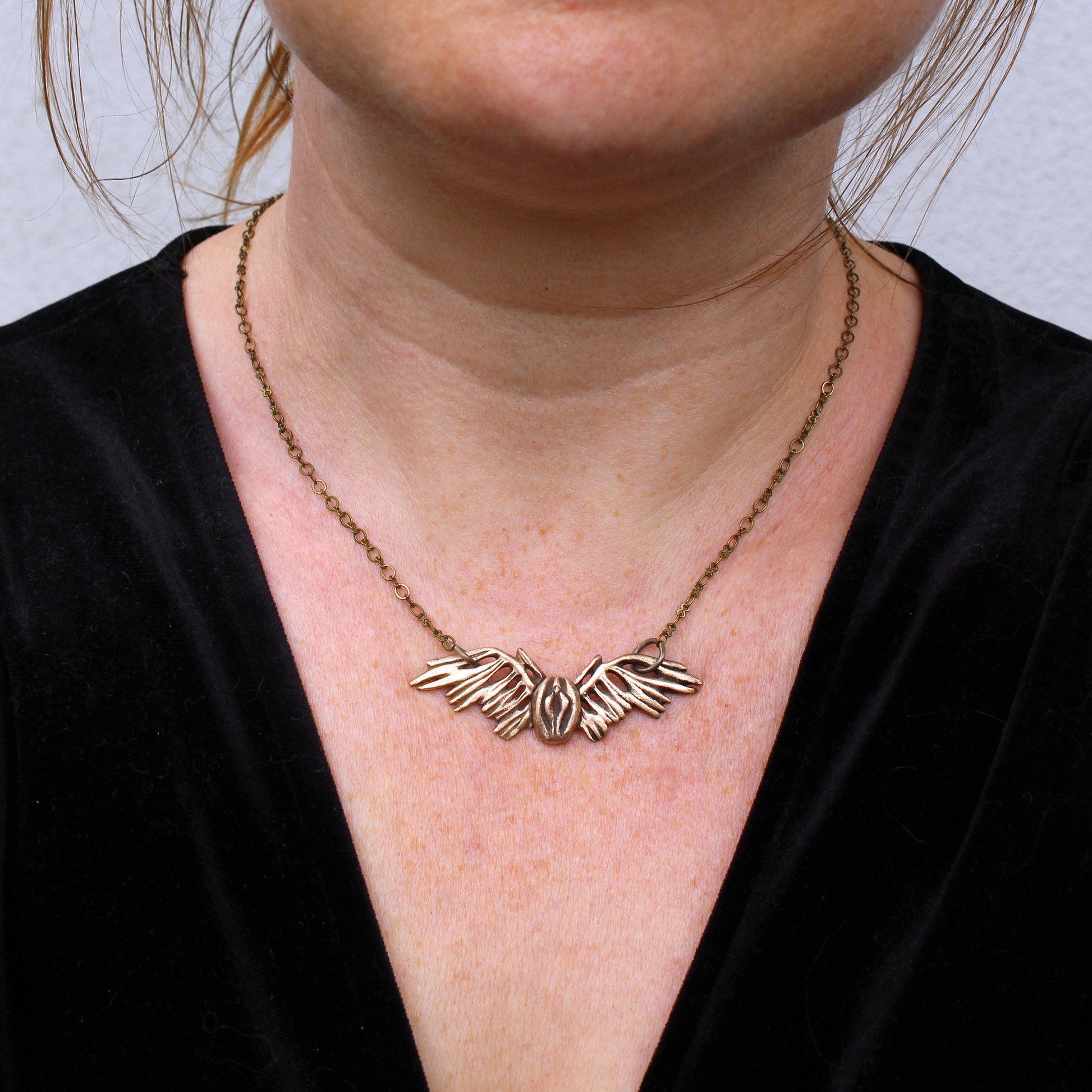 necklace with a vulva with wings