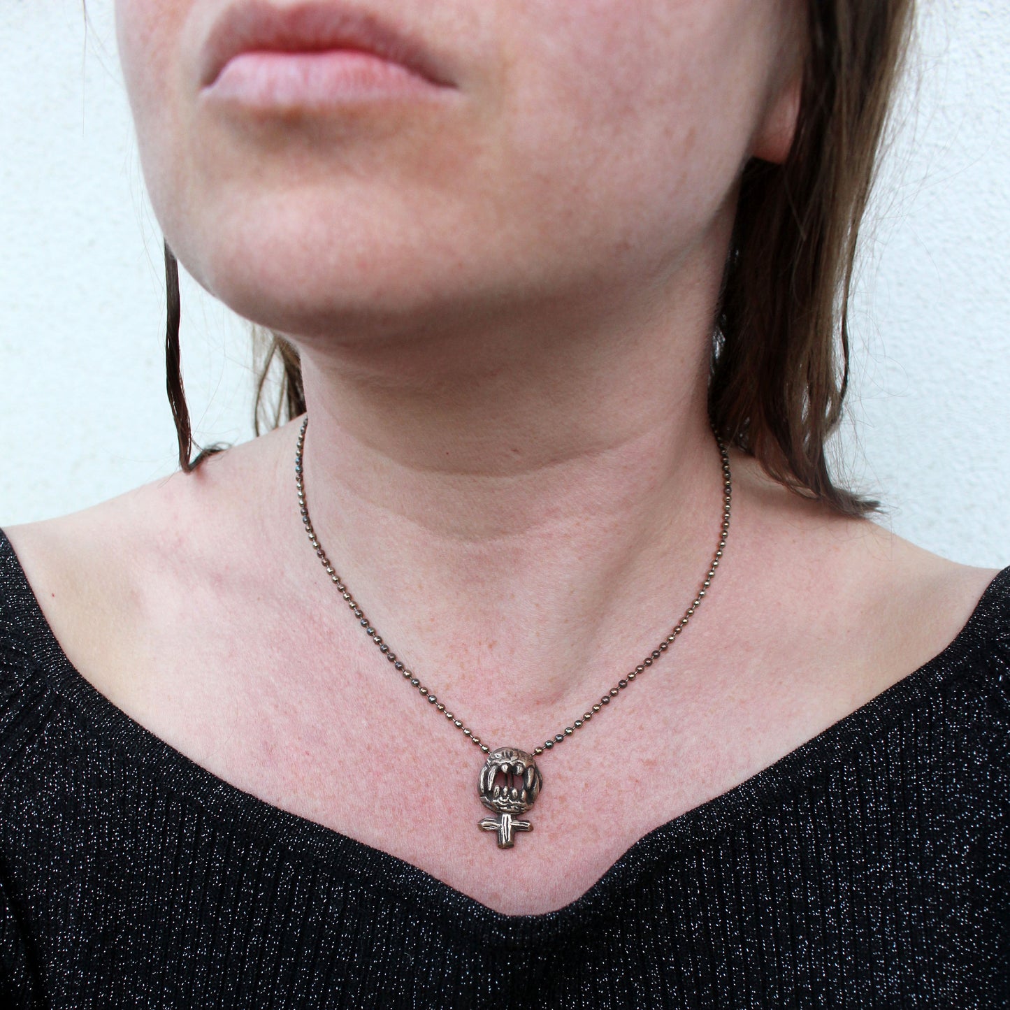 feministtecken feminist halsband med vassa tänder som hugger tillbaka, skulpterat i brons