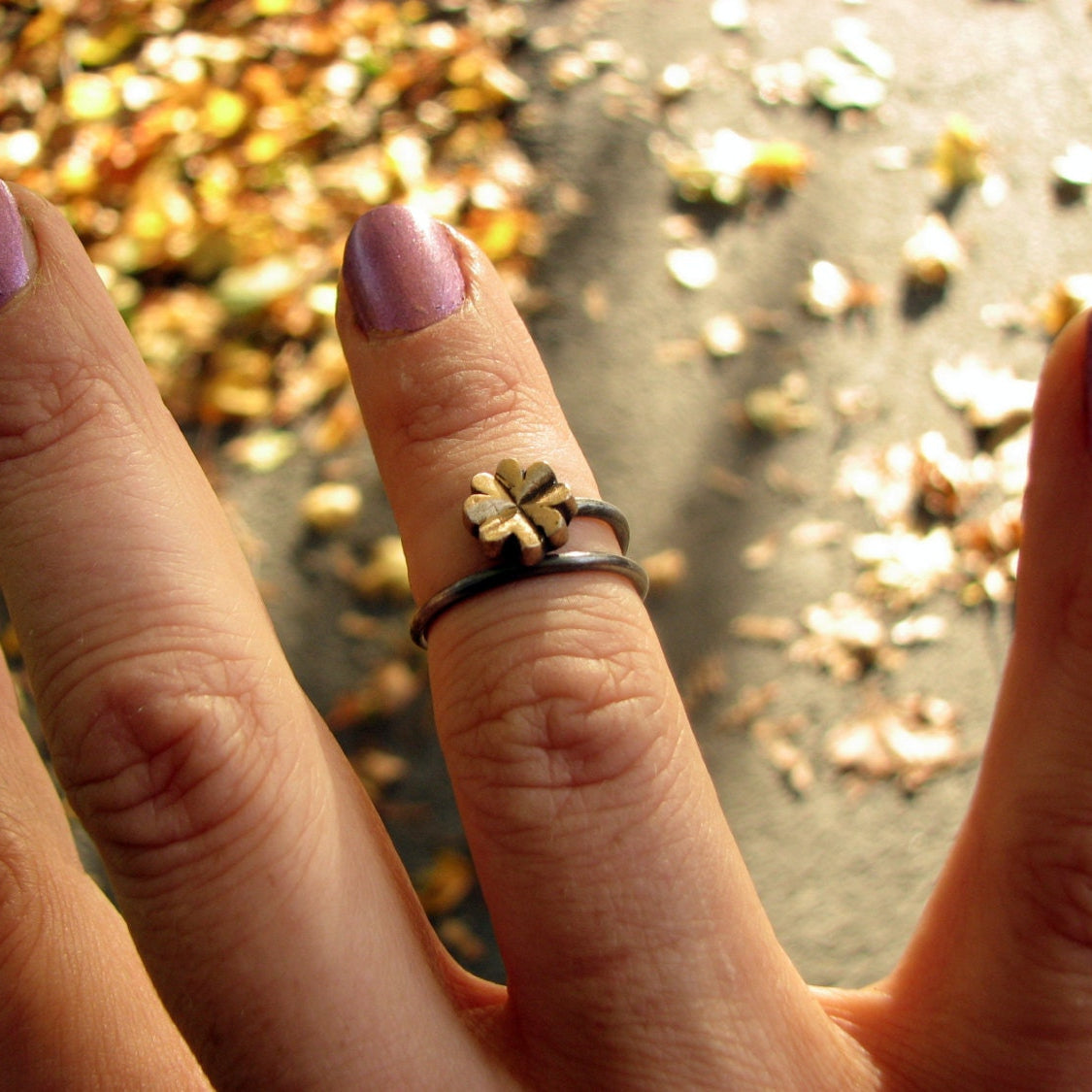 justerbar fingerring med en fyrklöver, i brons och rostfritt stål
