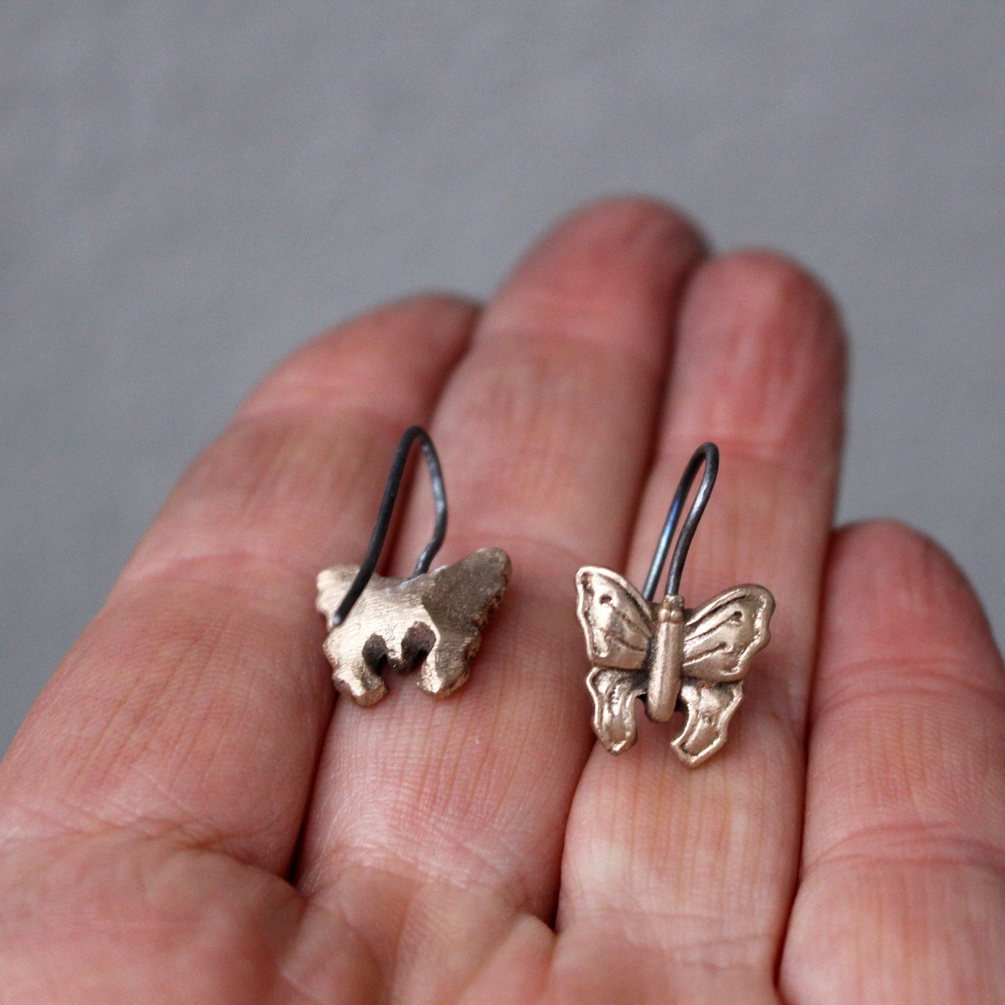 fjärilörhängen ligger i en persons hand