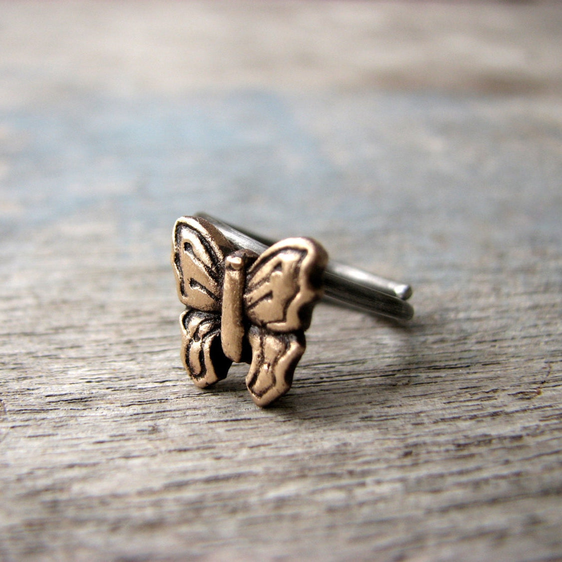 fingerring i brons och rostfritt stål me en fjäril