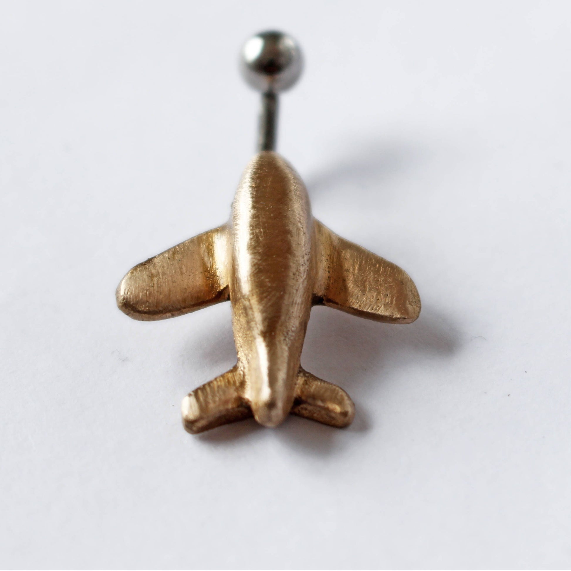 flygplan navelpiercingsmycke, piercingring med ett miniatyr flygplan handgjort i guldig brons
