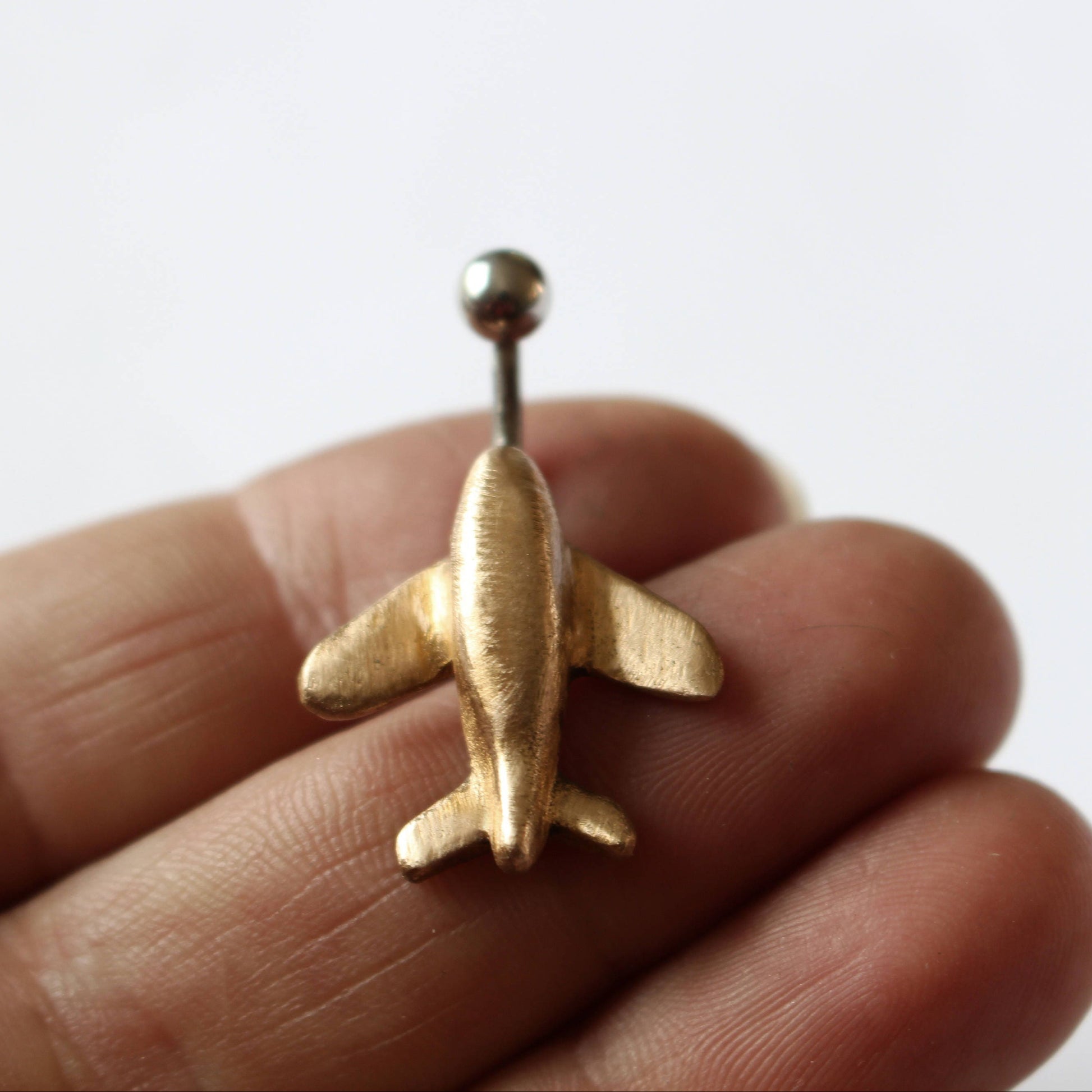 flygplan navelpiercingsmycke, piercingring med ett miniatyr flygplan handgjort i guldig brons