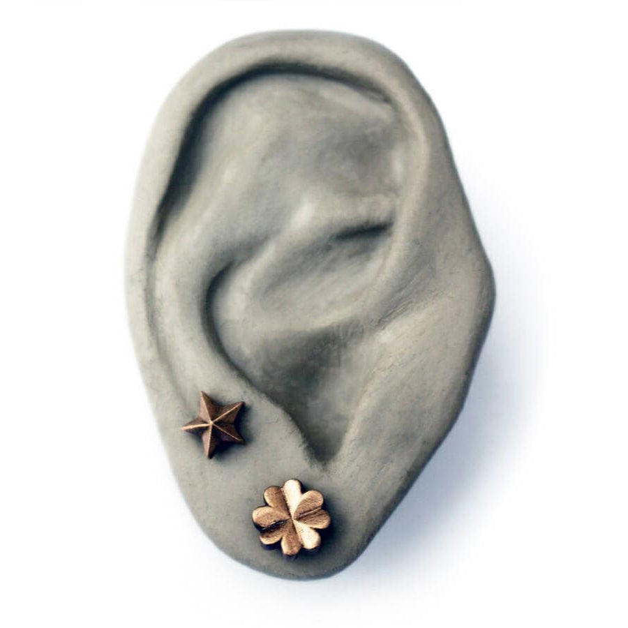 Grey ceramic ear with star and clover earrings on a white background