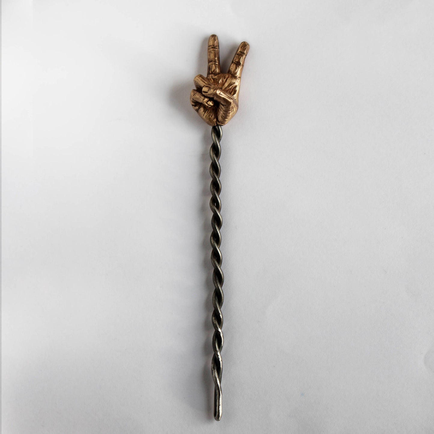 hair jewelry with a sculpted miniature hand making a peace sign with a forged stick from stainless steel