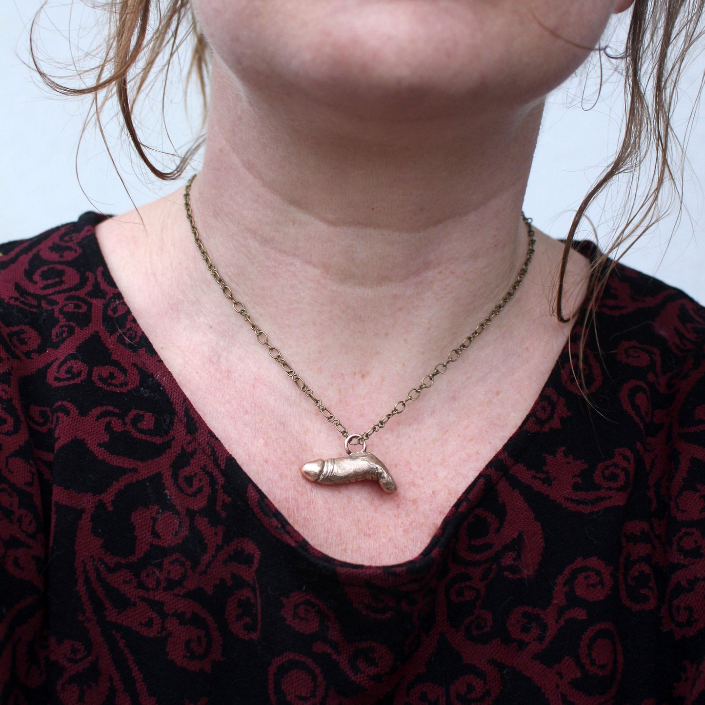 halsband med en erigerad penis skulpterad i brons, buren av skaparen anna siivonen