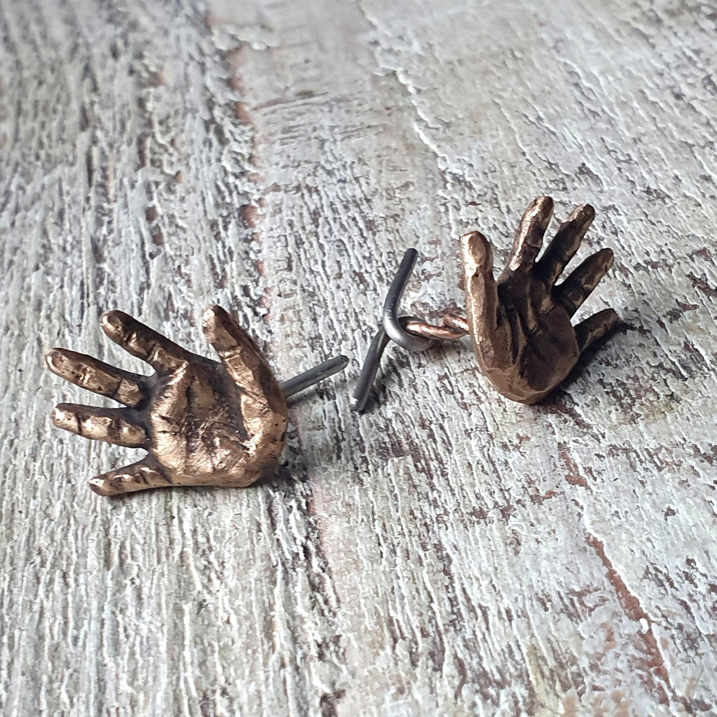 manschettknappar med miniatyr händer skulpterade i brons