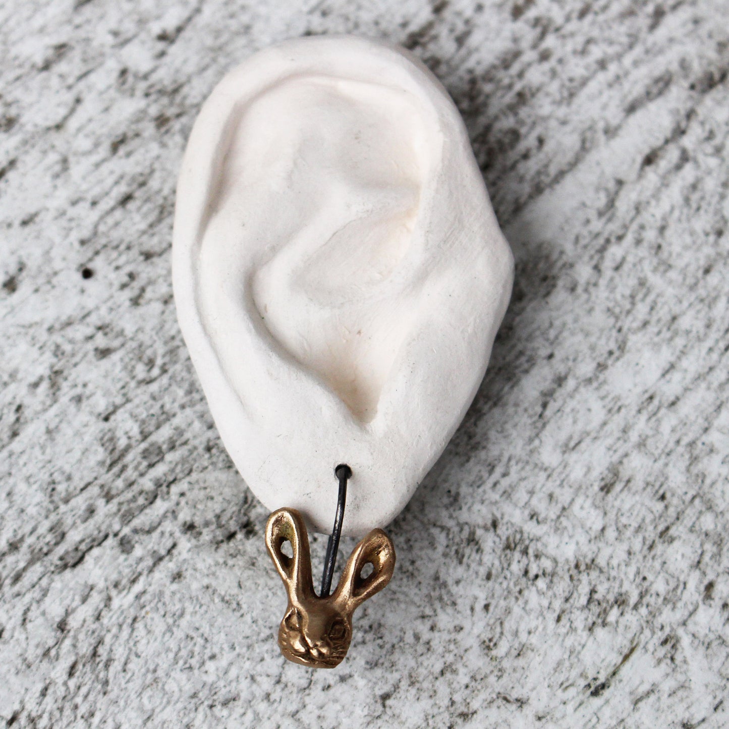 örhange med en skulpterad brons kanin med titankrok