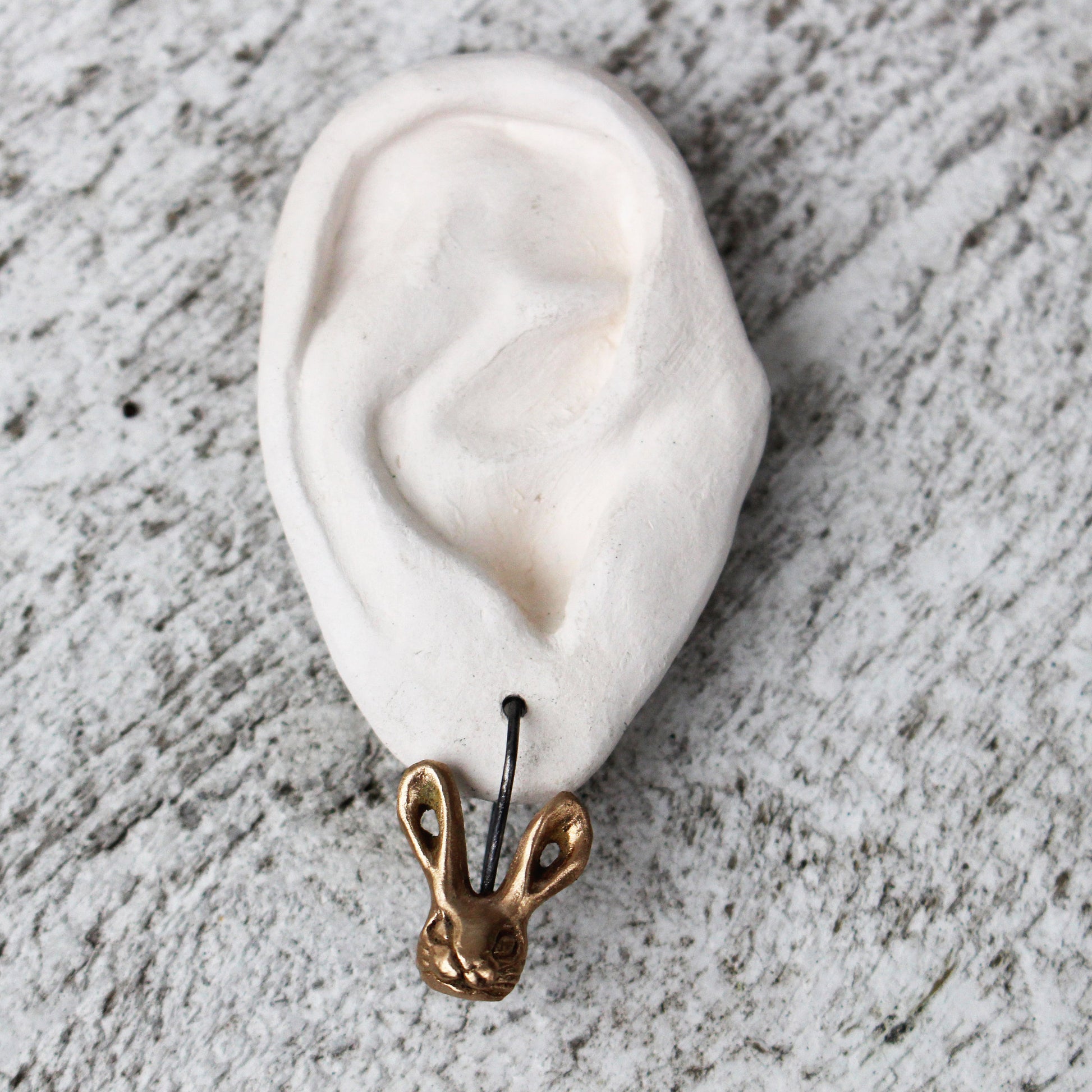 örhange med en skulpterad brons kanin med titankrok