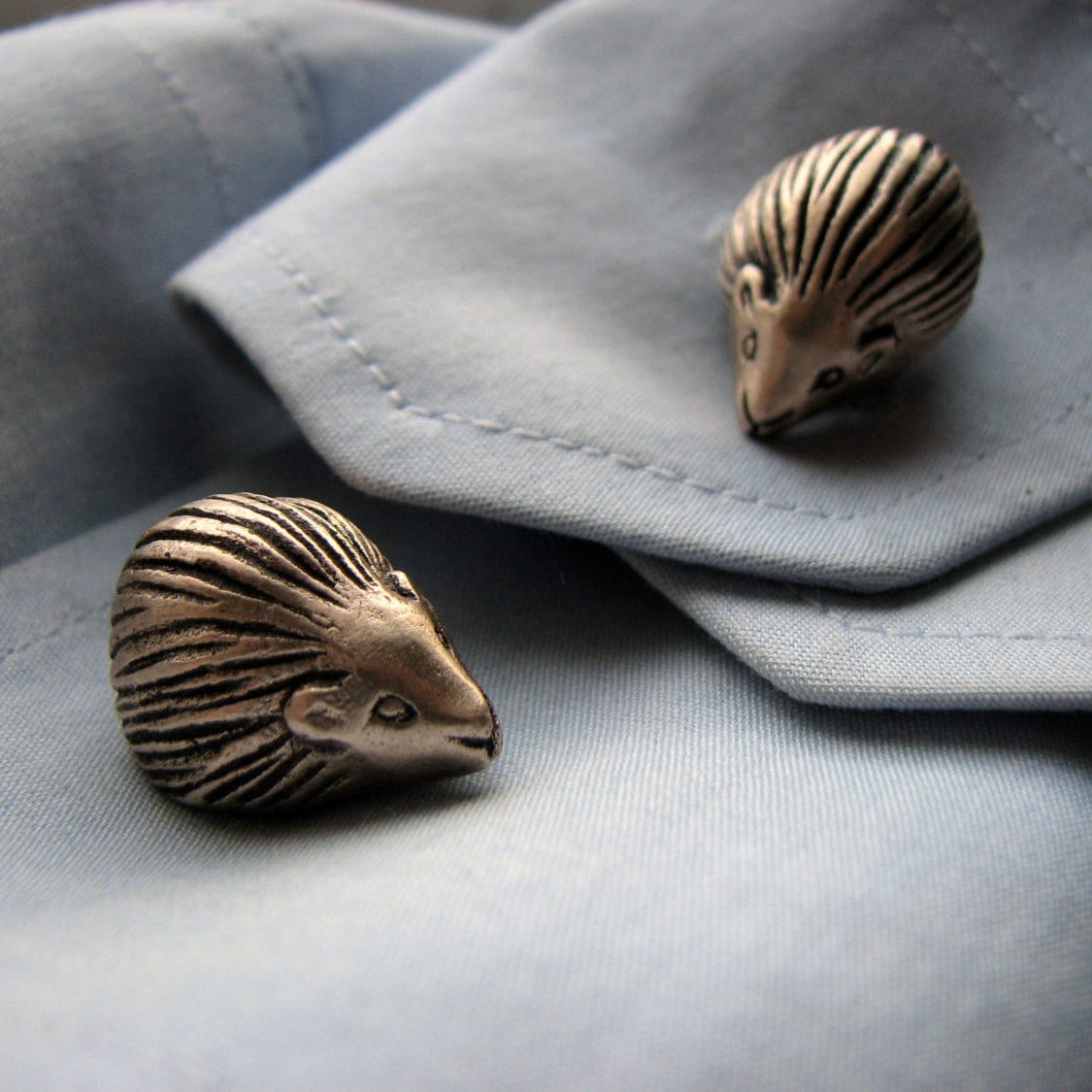 Bronze hedgehog shaped cufflinks on a light blue shirt