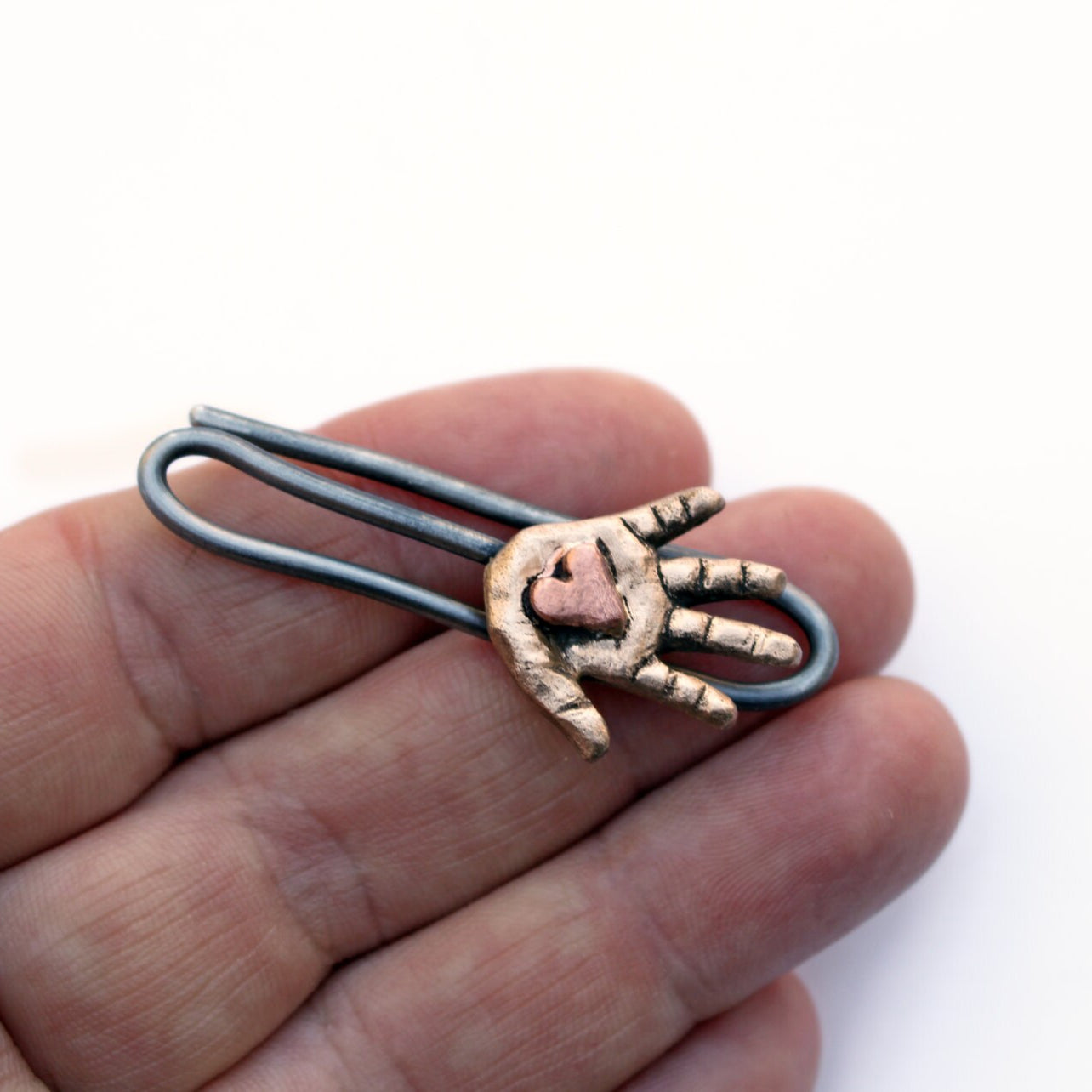 hjärtat i handen slipsklämma i brons, tål o koppar