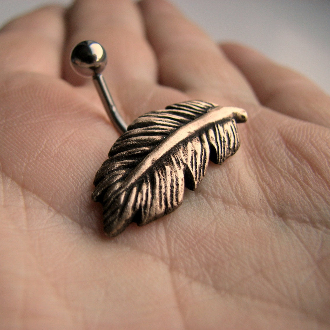 navelpiercing smycke med skulpterad fjader